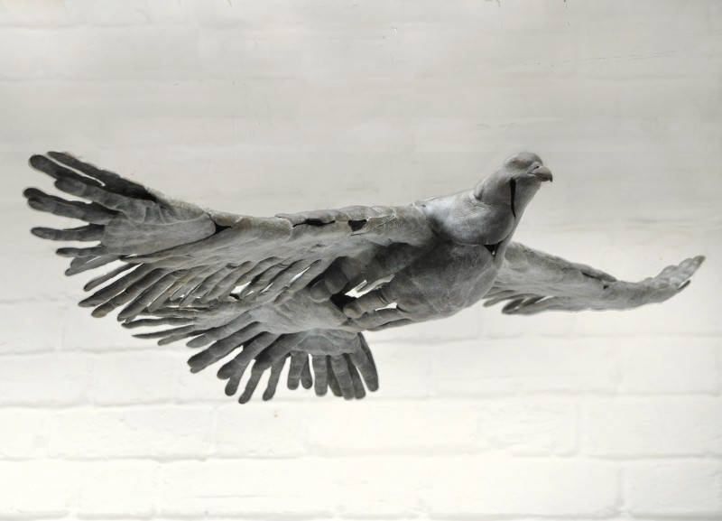 BIRD IN HAND - a bronze bird in flight made out of hand prints