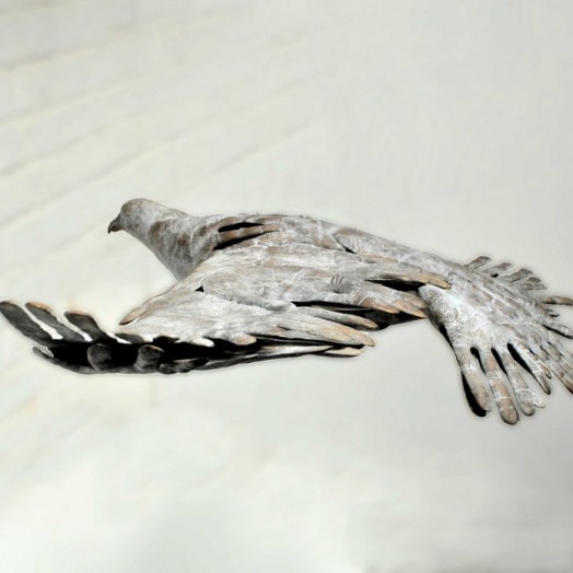 BIRD IN HAND - a bronze bird in flight made out of hand prints