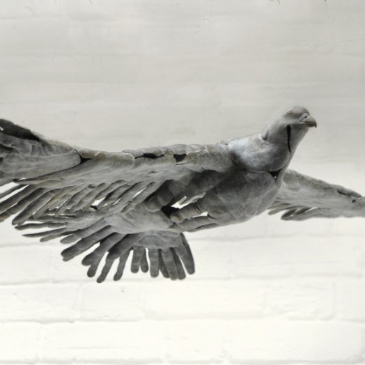 BIRD IN HAND - a bronze bird in flight made out of hand prints